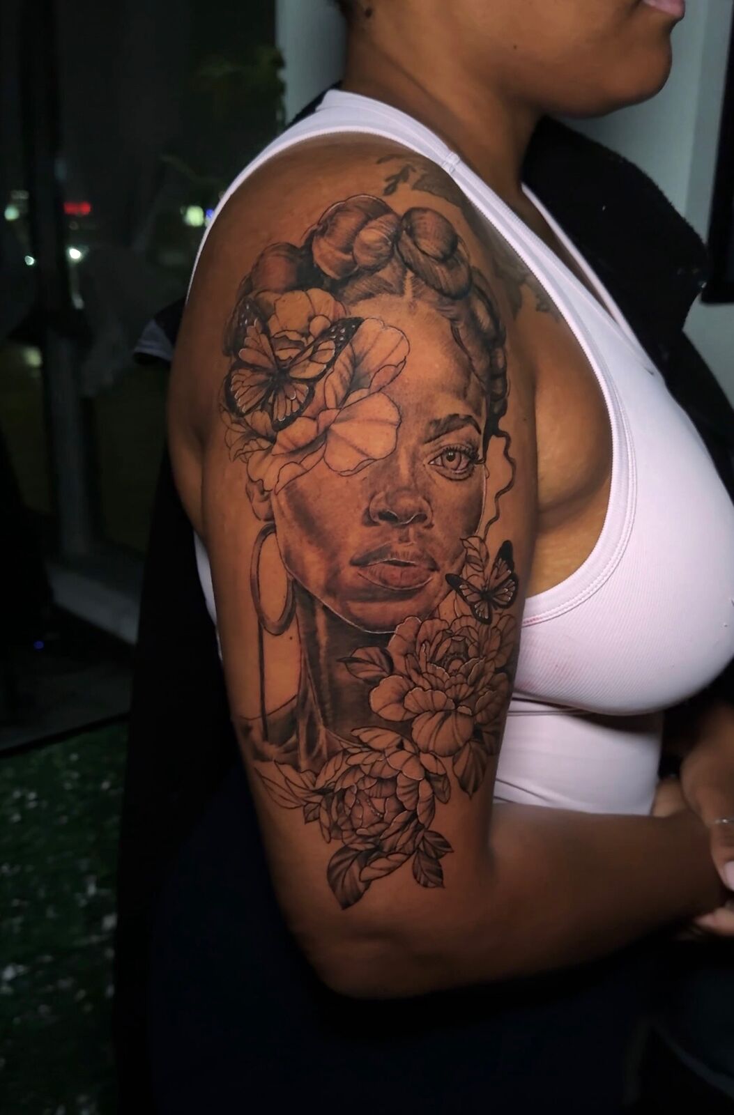 Black and grey portrait of a woman with roses on an upper arm